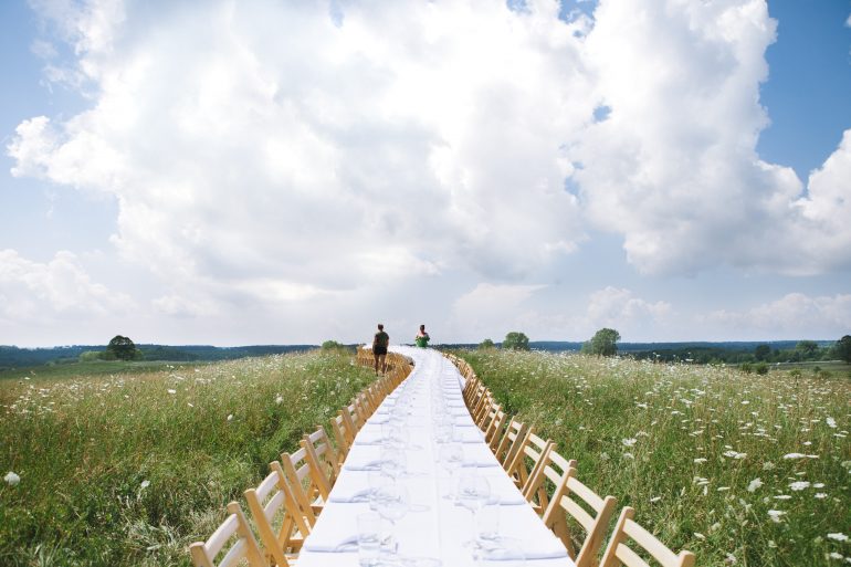 一本の長いテーブルの野外ディナー。「Outstanding in the Field」が示す食のつながり