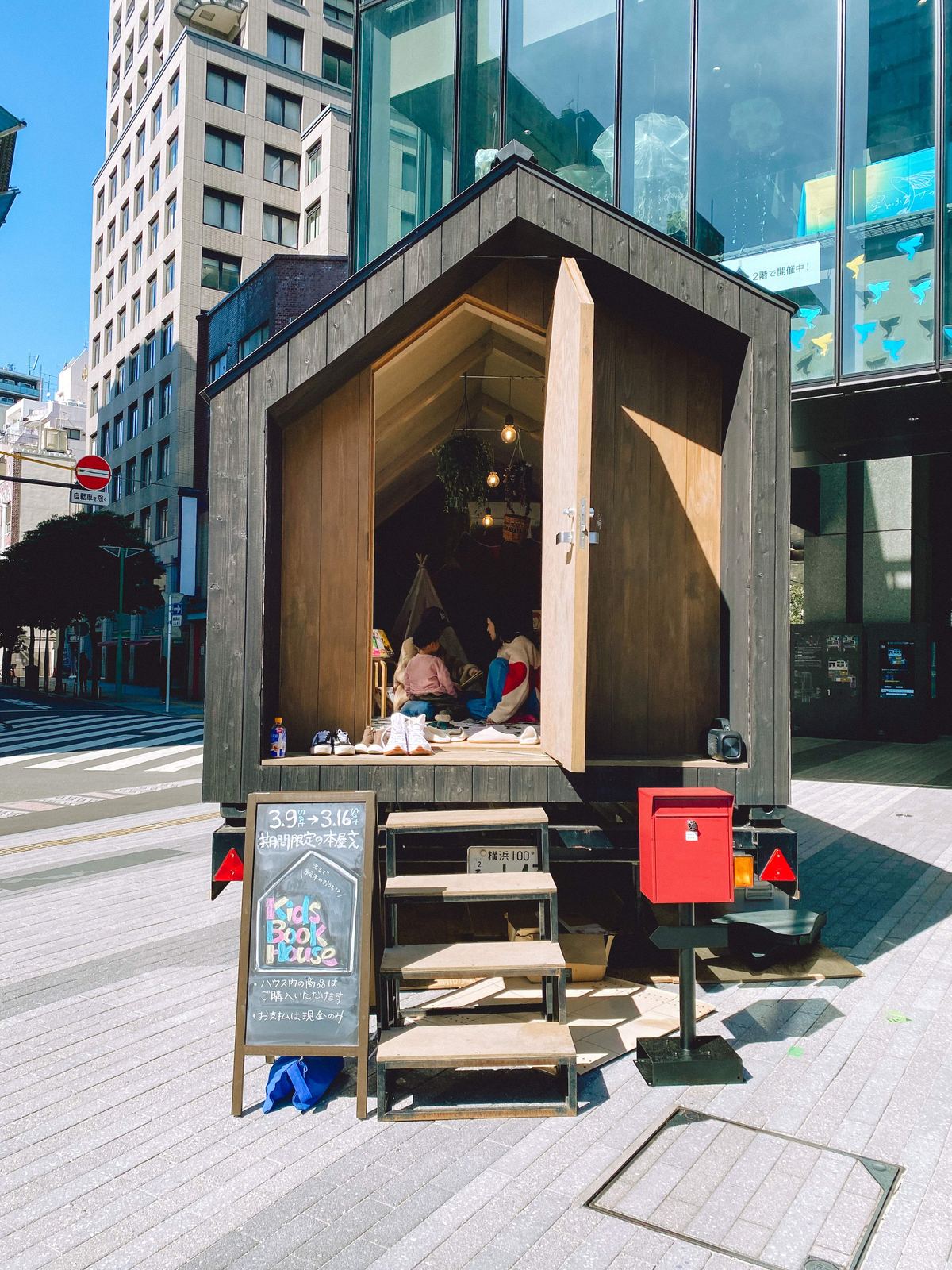 ビルの前に置かれた三角屋根の小屋