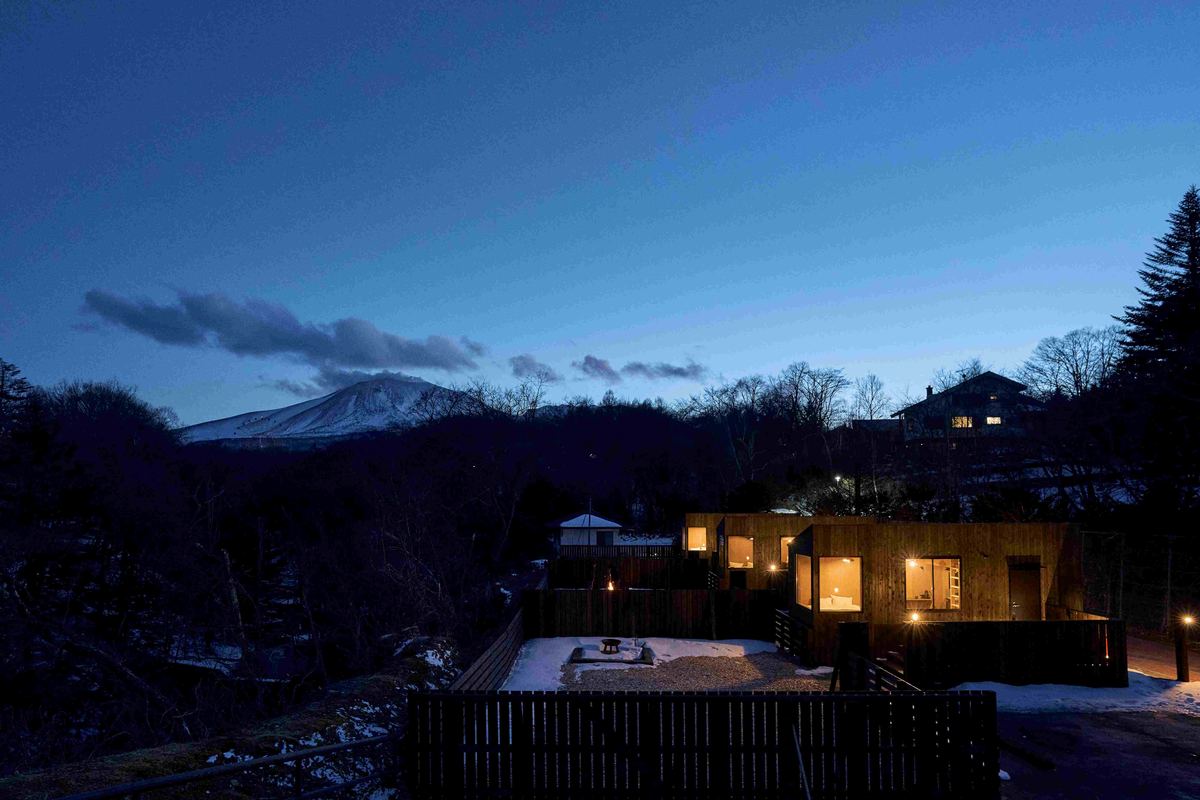 夜の山あいに明かりが灯る宿泊棟