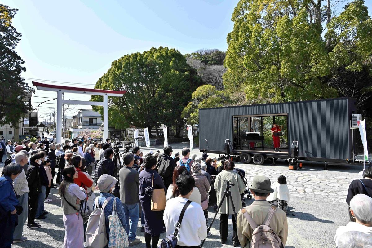 鳥居のそばに置いたトレーラーハウスのステージと、集まった観客