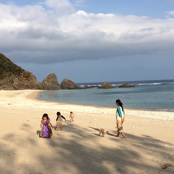 夕暮れ時のビーチで遊ぶ来島してくれた友人のお子さんと同じ移住者のご家族と飼い犬。毎日のようにある、のどかな風景です。