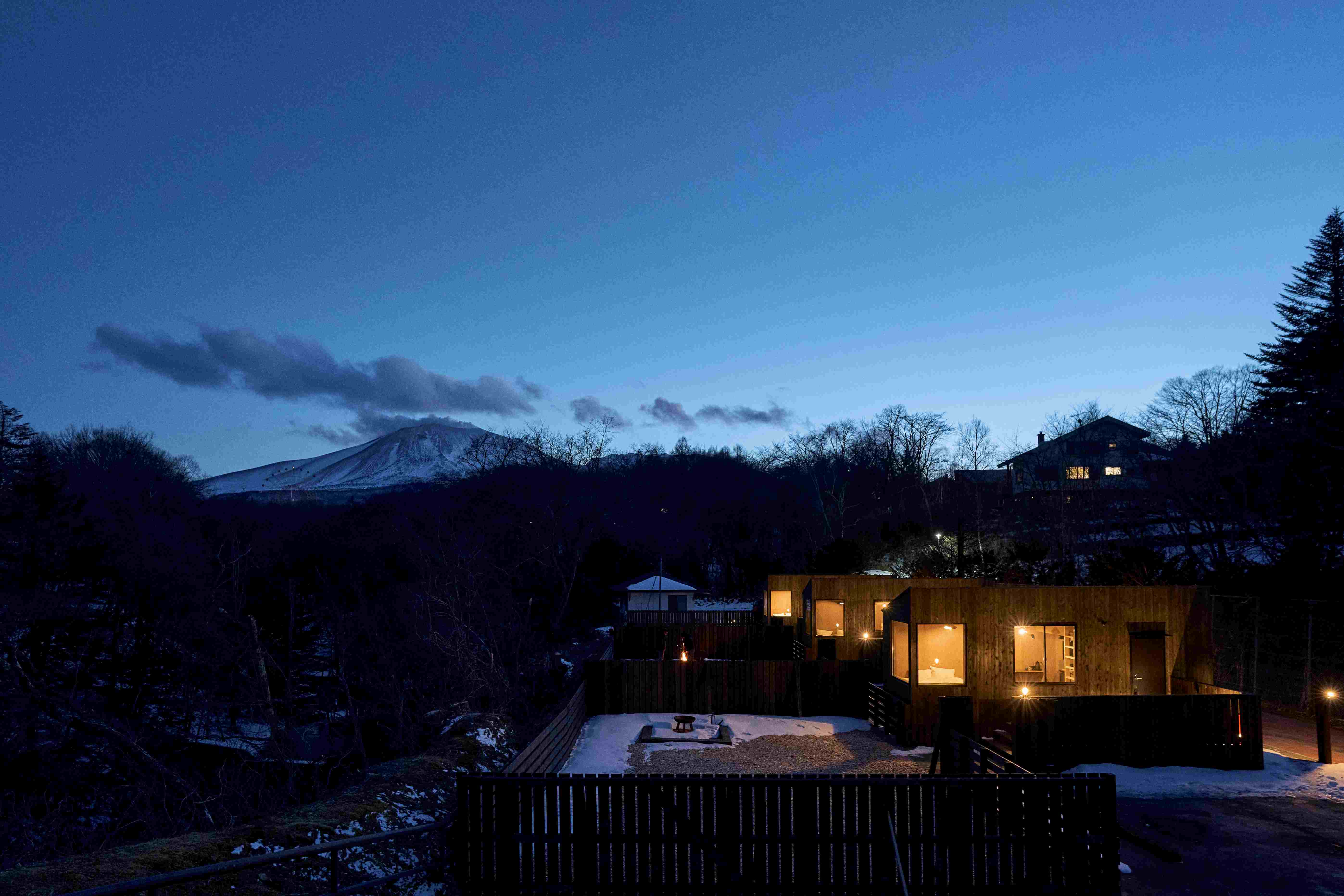 夜の山あいに明かりが灯る、トレーラーハウスの宿泊施設